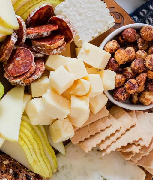 A top-down view of a charcuterie board featuring Oregon cheeses, assorted meats, nuts, and fruit.
