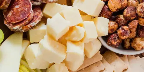 A top-down view of a charcuterie board featuring Oregon cheeses, assorted meats, nuts, and fruit.
