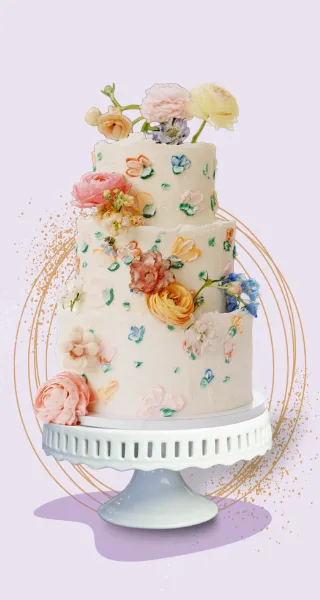 A three-tiered white wedding cake decorated with colorful buttercream flowers and fresh blooms, displayed on a white pedestal cake stand.