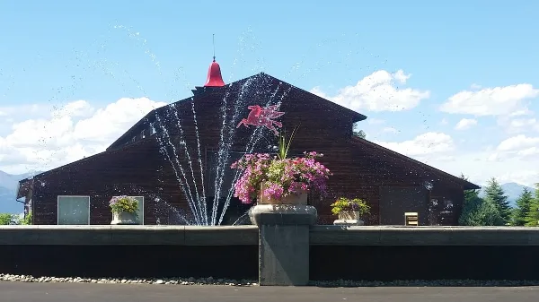 Exterior view of The Flying Horse MT venue building featuring a red bell and a flying horse sculpture.