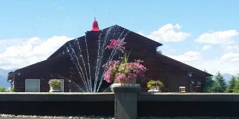 Exterior view of The Flying Horse MT venue building featuring a red bell and a flying horse sculpture.