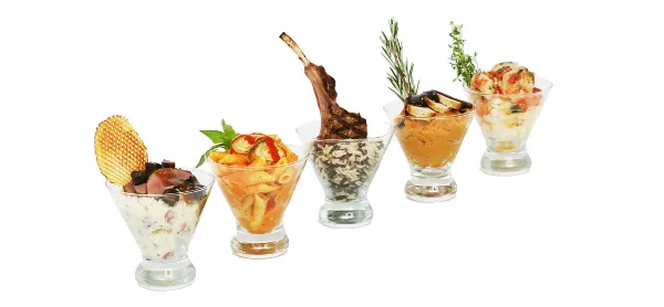 A row of five gourmet appetizers served in glass cups, featuring various dishes including pasta, a lamb chop, and shrimp.