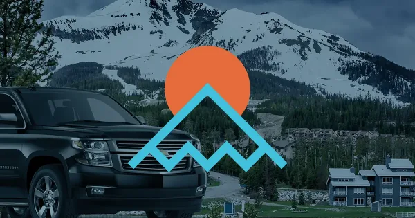 A black Chevrolet Suburban SUV parked in front of a snowy mountain landscape with a mountain logo overlay.