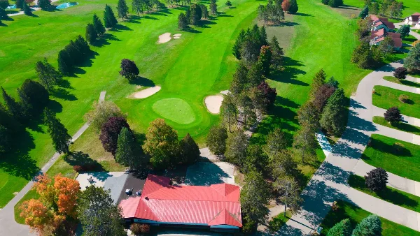 Aerial view of the Otsego Resort golf course and red-roofed lodge building.