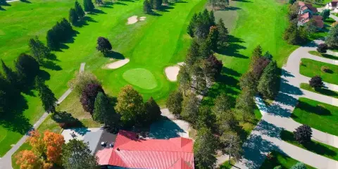 Aerial view of the Otsego Resort golf course and red-roofed lodge building.