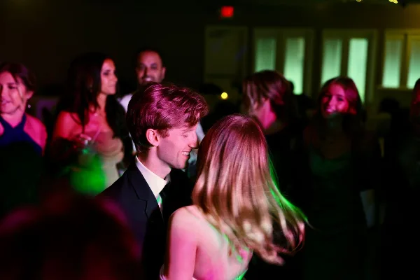 Bride and groom dancing at a wedding reception under colored lights