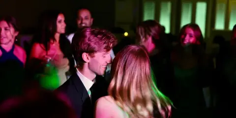Bride and groom dancing at a wedding reception under colored lights
