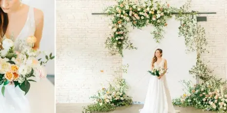 A bride holding a bouquet of white and peach roses next to a floral archway installation.
