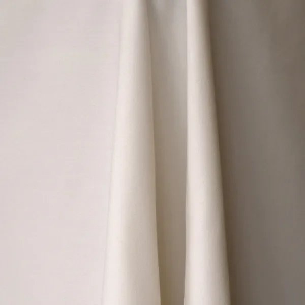 Close-up of a white polyester tablecloth with a smooth texture and draped folds.