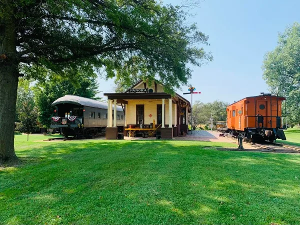 Exterior view of the Panora train depot and historic rail cars at the Guthrie County Historical Village and Museum.