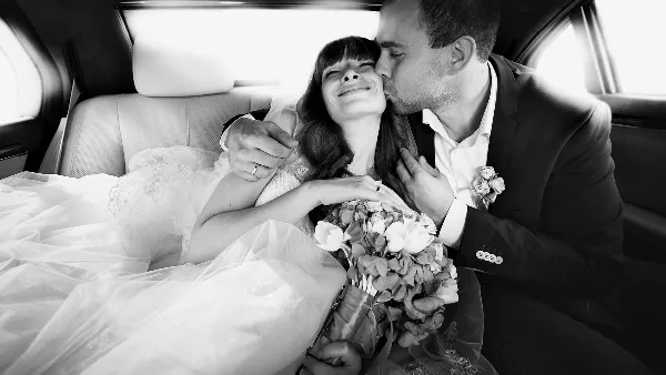 A bride and groom sharing a moment inside a limousine.