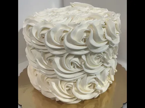 A white wedding cake decorated with piped rosette frosting.