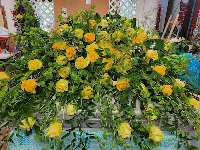 A large floral arrangement composed of yellow roses and green foliage.
