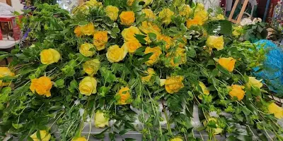 A large floral arrangement composed of yellow roses and green foliage.