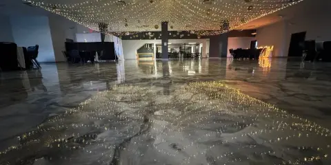 Interior view of a large event hall with polished marbled floors and a ceiling covered in string lights.