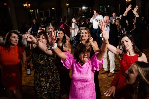 Wedding guests dancing together on a packed reception dance floor.