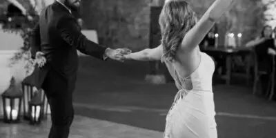 A black and white photograph of a bride and groom dancing at a wedding reception.