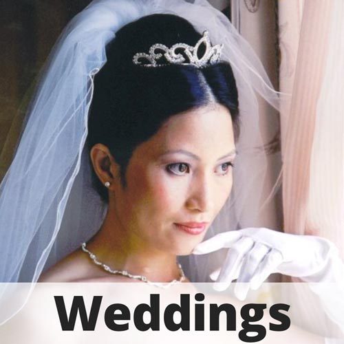 Portrait of a bride wearing a veil, tiara, and white glove with the word Weddings overlaid.