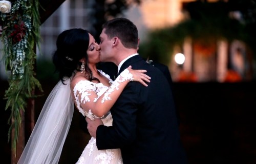 A bride and groom sharing a kiss during their wedding ceremony.