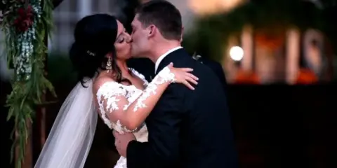 A bride and groom sharing a kiss during their wedding ceremony.