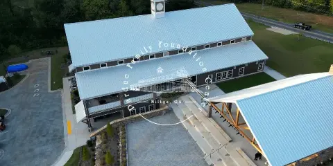 Aerial view of the Pardue Family Foundation Center event venue in Milton, GA, showing the main building, outdoor seating area, and surrounding grounds.