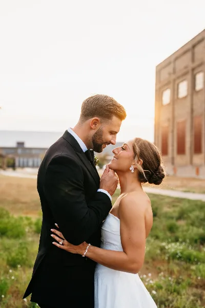 A bride and groom sharing an intimate moment outdoors during a wedding.