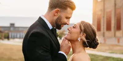 A bride and groom sharing an intimate moment outdoors during a wedding.