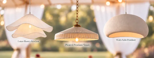 Three decorative pendant lights hanging inside a white tent with string lights in the background.