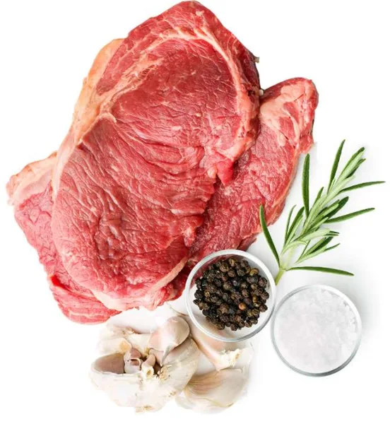 A large raw cut of red meat displayed with fresh rosemary, garlic, salt, and peppercorns.