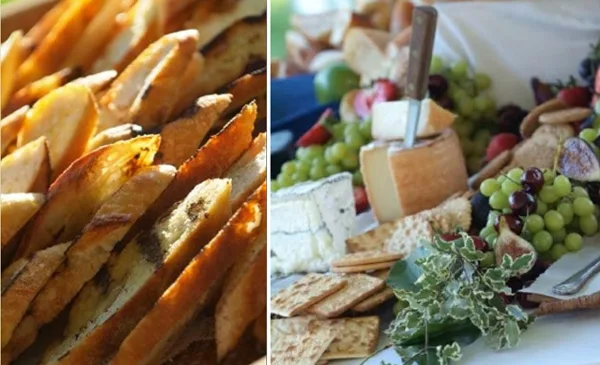 A close-up of a catering spread featuring a cheese and fruit board alongside roasted potatoes.