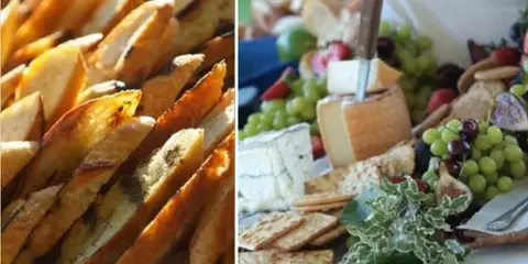 A close-up of a catering spread featuring a cheese and fruit board alongside roasted potatoes.