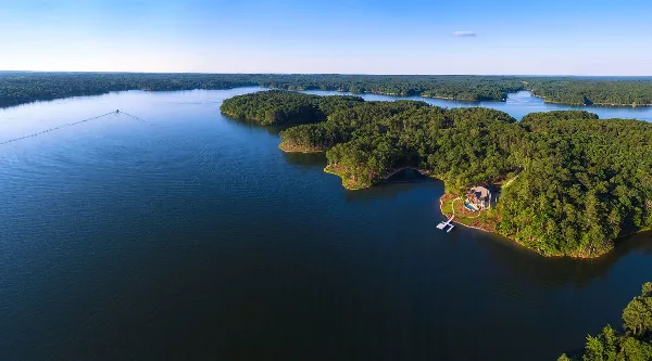Aerial view of a large lake with forested islands and a waterfront property.