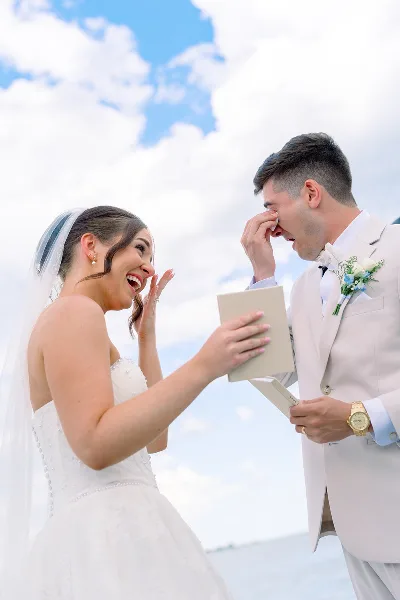 A bride and groom sharing a joyful, emotional moment during their outdoor wedding ceremony.