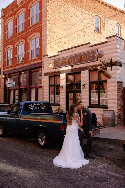 A bride and groom posing in front of The Courtyard venue building in Bisbee, Arizona.