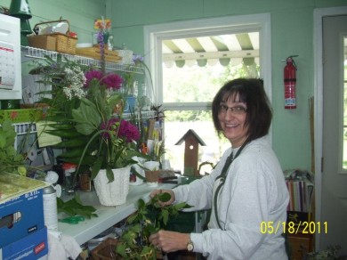 A woman arranging flowers inside a flower shop.
