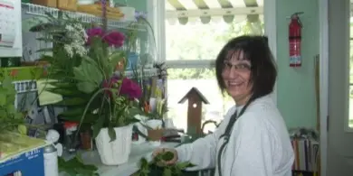 A woman arranging flowers inside a flower shop.