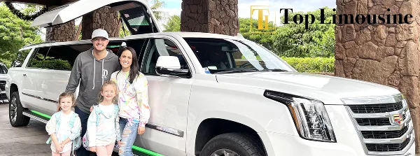 A family posing next to a white stretch limousine at a resort entrance.