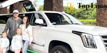 A family posing next to a white stretch limousine at a resort entrance.
