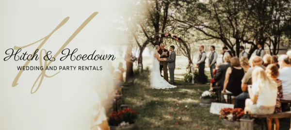 Outdoor wedding ceremony under a floral arch with guests seated on benches and floral arrangements nearby