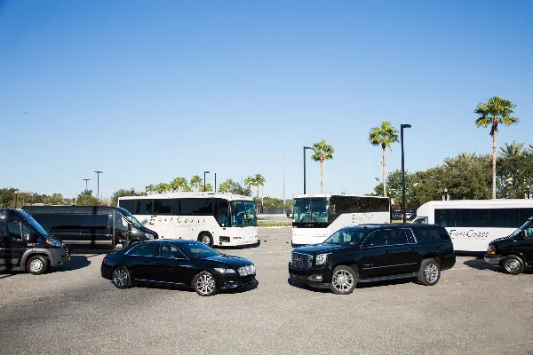 A fleet of black and white East Coast Transportation vehicles, including sedans, SUVs, and buses, parked in a lot.