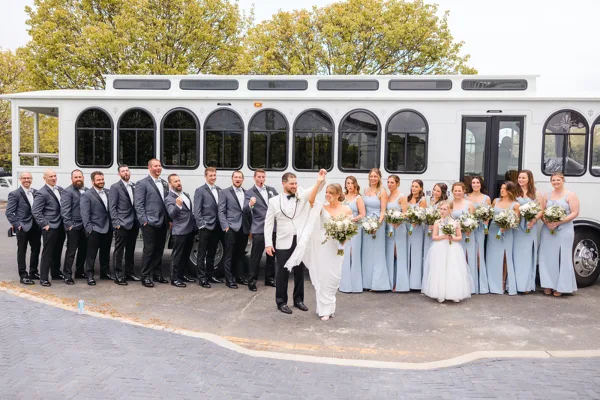 A wedding party posing outside of a Shooboo trolley