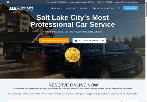 A black SUV and a white van with Canyon Transportation branding parked in a lot.
