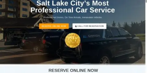 A black SUV and a white van with Canyon Transportation branding parked in a lot.