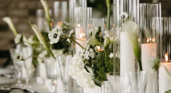 Elegant wedding table setting with white flowers, candles, and glassware