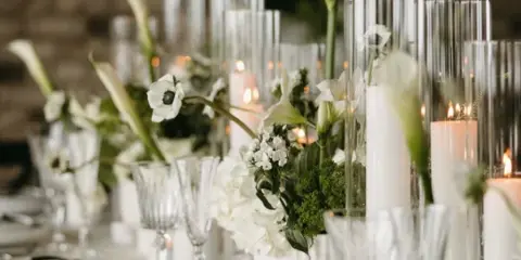 Elegant wedding table setting with white flowers, candles, and glassware
