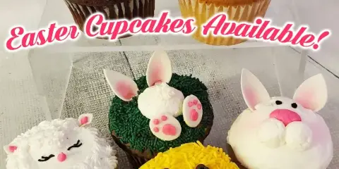 A collection of decorated cupcakes featuring Easter-themed designs such as a bunny, a chick, and a lamb.