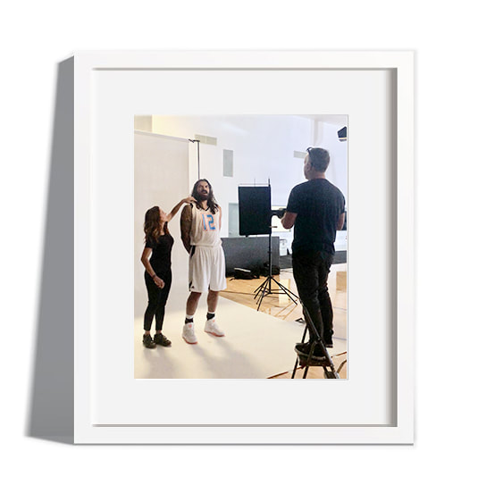 A makeup artist applying makeup to a client in a professional studio setting.
