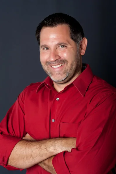 Portrait of Robert Cobo, owner of Siskiyou DJ, wearing a red shirt.