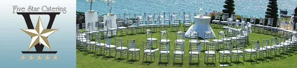 Waterside wedding ceremony setup with white chairs, cocktail tables, and a blue ocean backdrop.