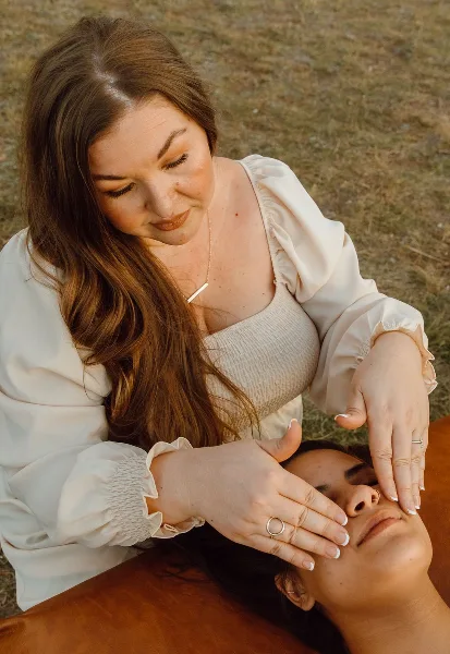 An esthetician performing a facial treatment on a client outdoors.